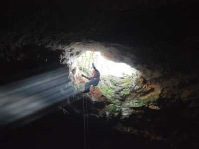 Nella grotta si accede solamente calandosi dall'alto, legati a una corda e muniti di elmetto protettivo...